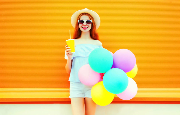 Fashion smiling woman holds a fruit juice cup with an air colorf - Fotografie, Obrázek