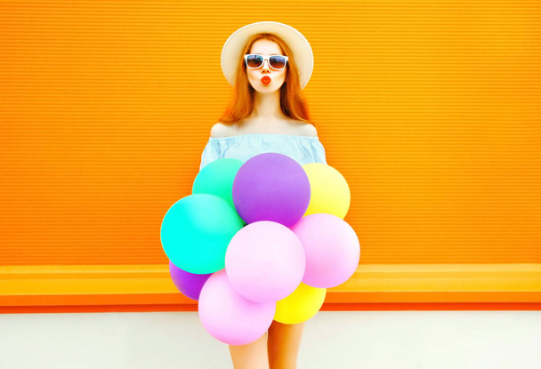 Fashion woman make an air kiss with an air colorful balloons on  - Foto, afbeelding