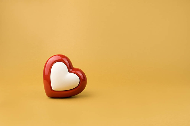 Red heart on yellow background - Foto, afbeelding