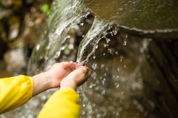 Kleine jongen de handen met water splash - Foto, afbeelding