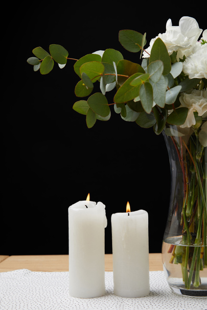 Vase avec bouquet de fleurs et bougies sur table sur fond noir
 - Photo, image