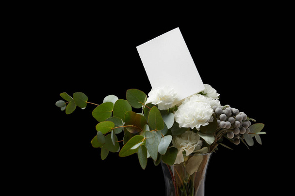 Floral bouquet with white card isolated on black - Photo, Image