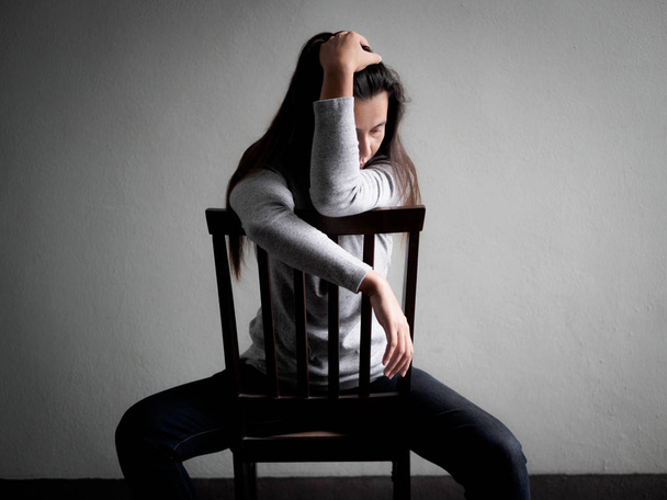 Депресивна розбита сердита жінка сидить на самоті на дерев'яному стільці
  - Фото, зображення