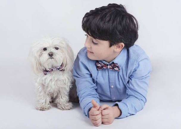 Junge liegt neben seinem Hund auf weißem Hintergrund - Foto, Bild