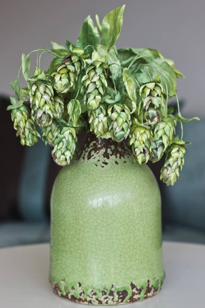Cones of green hops. Artificial silk flowers in the interior - Photo, Image