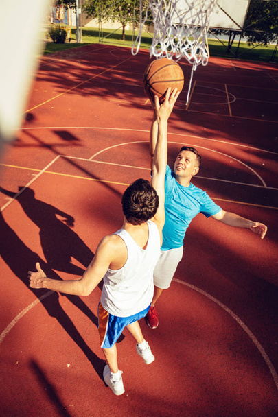 Deux joueurs de basket-ball de rue s'entraînent en plein air. Ils font une bonne action
. - Photo, image