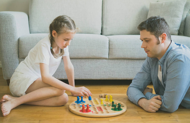Little girl and her father playing ludo. - Photo, Image