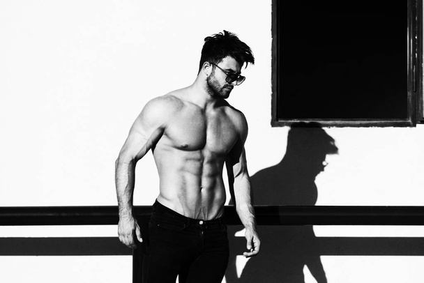 Portrait of Muscular Man Standing Near the Wall - Foto, Imagen
