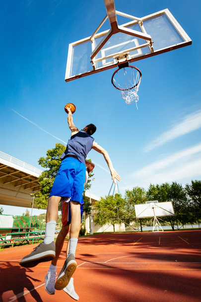 Dos jugadores de baloncesto callejeros entrenando al aire libre. Están haciendo una buena acción.
. - Foto, Imagen