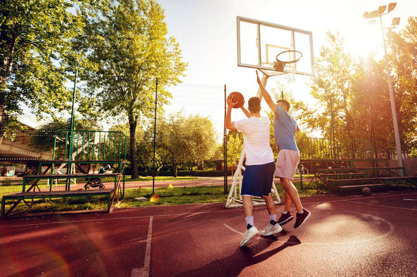 Dva pouliční basketbal hráči mají venkovní trénink. Oni dělají dobré akce. - Fotografie, Obrázek