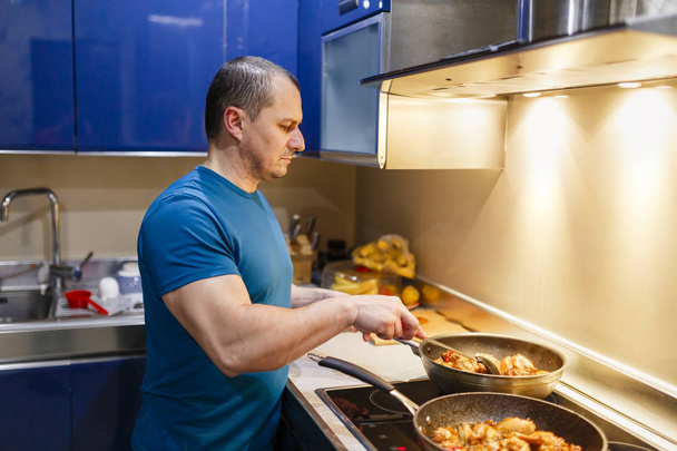Człowiek w kuchni gotuje się w domu w wok - Zdjęcie, obraz