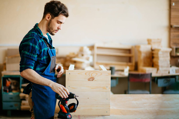 Young male carpenter in workshop looking at camera - Foto, Imagem