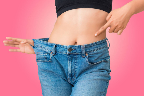 Jeune femme montrant une perte de poids réussie avec son jean
  - Photo, image