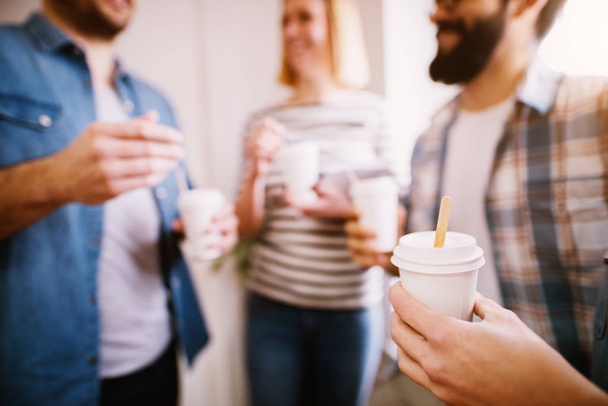 група молодих щасливих колег, які розважаються на перерві під час пиття кави
 - Фото, зображення