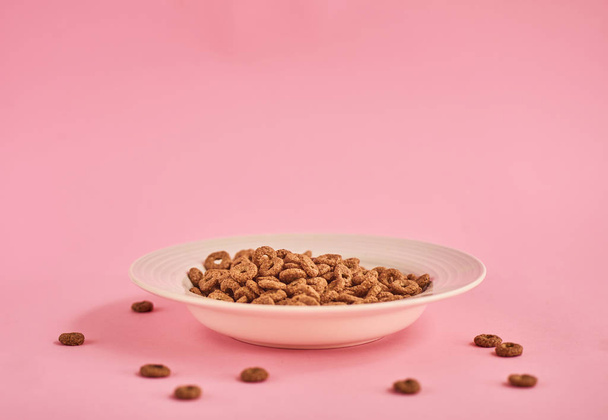 Vértes gabonaféléknek a rózsaszín háttér, fehér lemez - Fotó, kép
