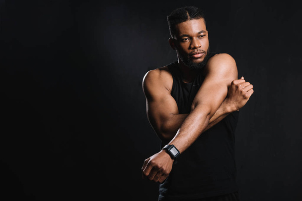 muscular african american man stretching hands isolated on black - 写真・画像