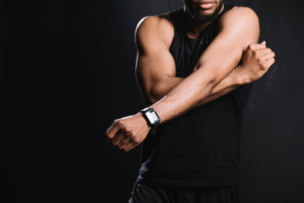 cropped shot of muscular african american man stretching hands isolated on black - Φωτογραφία, εικόνα
