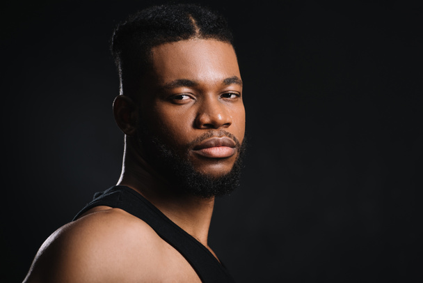 portrait of handsome young athletic african american man looking at camera isolated on black - Fotografie, Obrázek