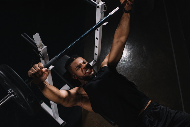 high angle view of young african american sportsman lifting barbell  - Φωτογραφία, εικόνα