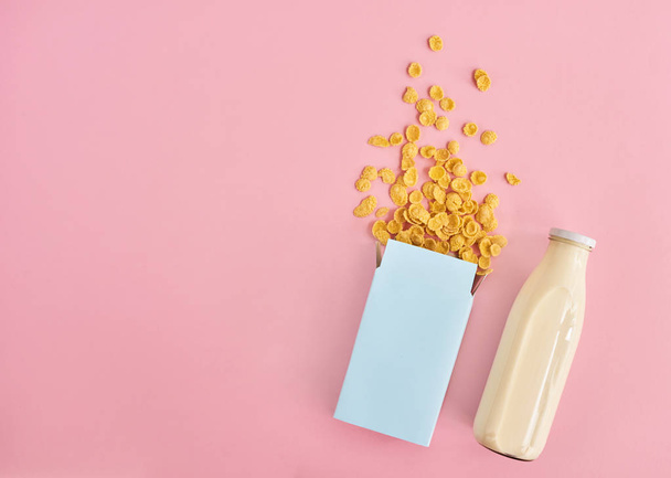 Scatola di cereali e bottiglia di latte su sfondo rosa, vista dall'alto. Design mockup con spazio per inserire il testo
 - Foto, immagini