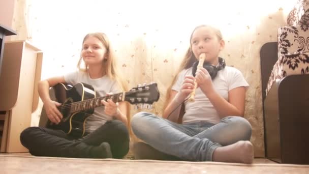 Две девочки-подростки играют на музыкальных инструментах дома
 - Кадры, видео