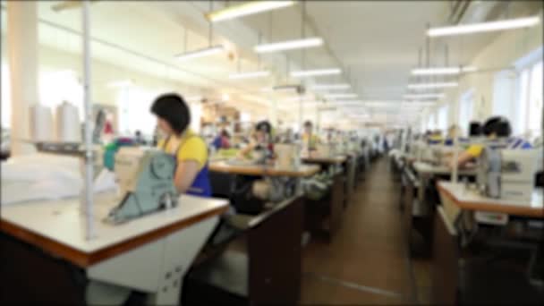 Teollisuuden koko tekstiili tehdas, työntekijät tuotantolinjalla, ompelu tuotanto, naiset työskentelevät ompelukoneet, ompelu työpaja, hämärä, tunnistamaton
 - Materiaali, video