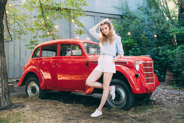 girl next to an old red car - Foto, afbeelding