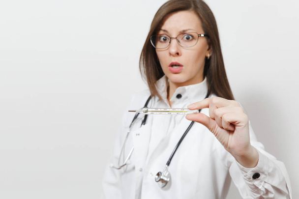 Κοντινό πλάνο Γυναίκα σοκαρισμένος ο γιατρός στην ιατρική εσθήτα, με στηθοσκόπιο, γυαλιά. Επικεντρωθεί σε κλινικό θερμόμετρο με υψηλό πυρετό θερμοκρασία που απομονώνονται σε λευκό φόντο. Νοσηλευτικού προσωπικού, ιατρική έννοια. - Φωτογραφία, εικόνα