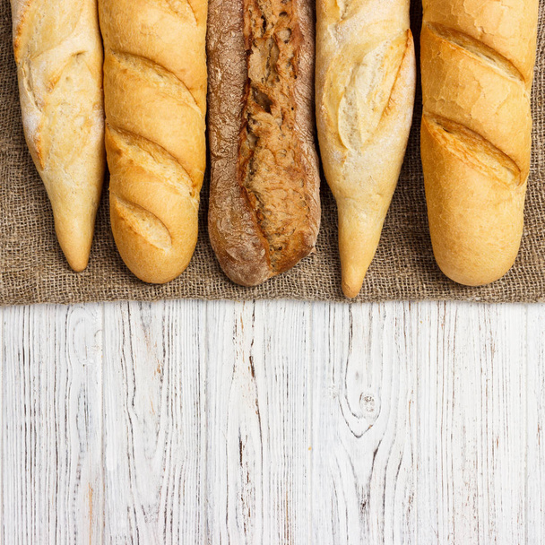 Sortiment frischer französischer Baguettes auf einem Holztisch - Foto, Bild