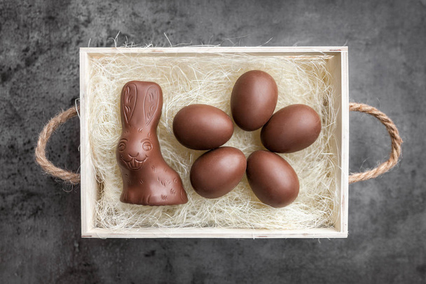Chocolate Easter bunny and eggs on rustic background - Photo, Image