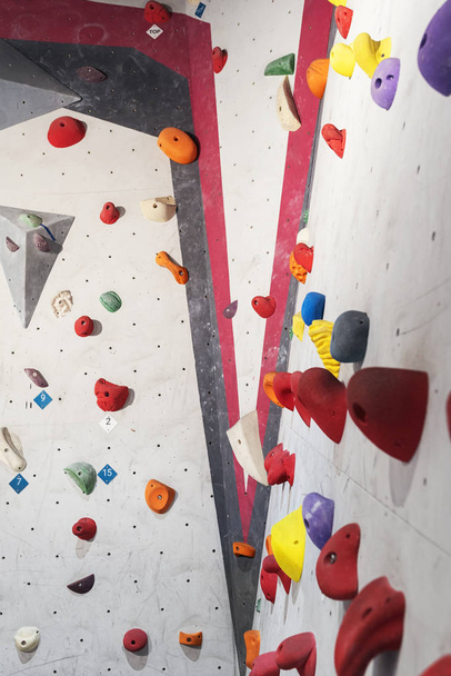 Grey wall with climbing holds and ropes in gym. - Fotoğraf, Görsel