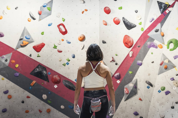 Unrecognizable woman ready for practice rock climbing on artificial wall indoors. - 写真・画像