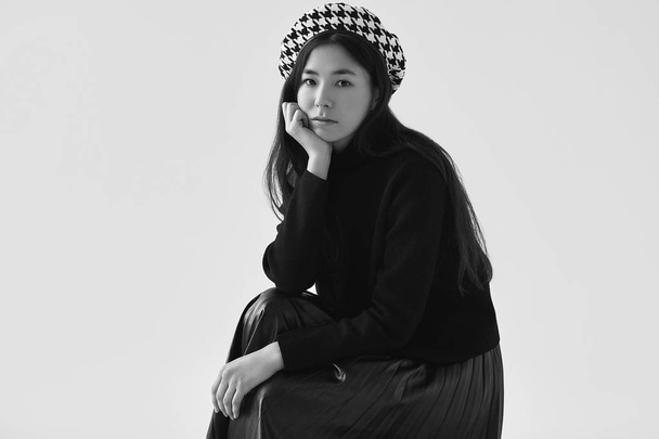 エレガントなアジアの女性のファッショナブルな黒スカート、ベレー帽 - 写真・画像