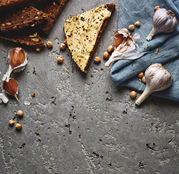sliced whole wheat bread, chickpea and garlic on the grey concrete backdrop - Foto, Bild