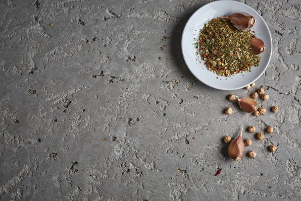 a plate of spices, chickpea and garlic on the grey concrete backdrop - Foto, afbeelding