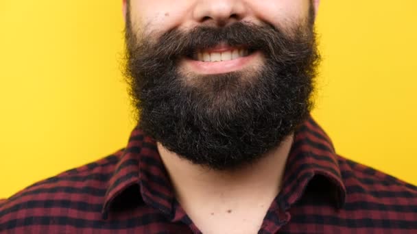 Homem barbudo irreconhecível sorrindo para a câmera em fundo amarelo
 - Filmagem, Vídeo