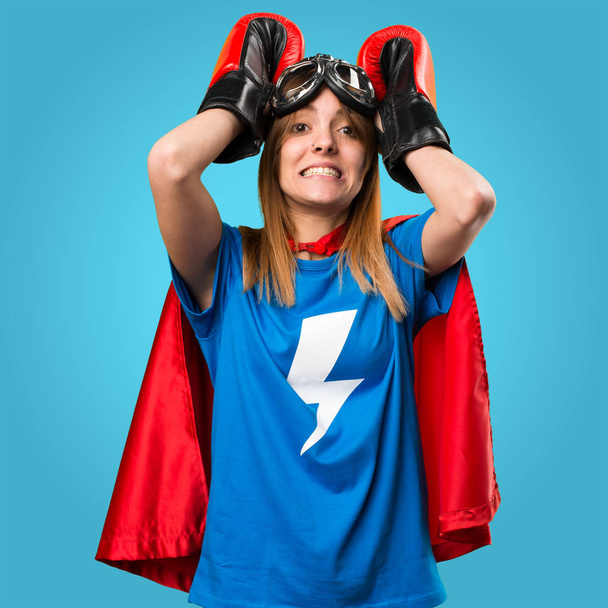 Chica superhéroe frustrado con guantes de boxeo en backgro colorido
 - Foto, imagen