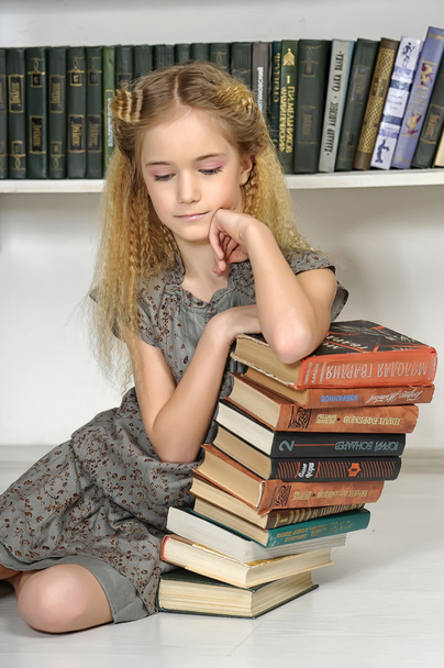 Girl in the library with a stack of books - Фото, зображення