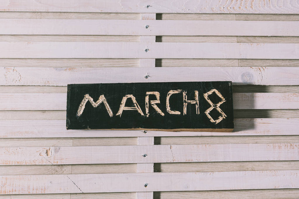 napis "8 marca" jest wycięty na czarnej płycie. gr - Zdjęcie, obraz