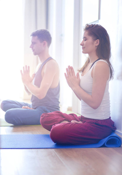 Young healthy couple in yoga position on white background - Φωτογραφία, εικόνα