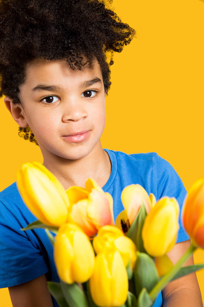 Adorable little boy holding tulips present - Фото, изображение