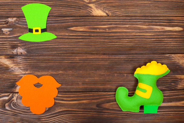 Tema St. Patrick 's Day banner horizontal colorido. Sombrero de duende verde, barba y zapato con oro sobre fondo de madera marrón. Elementos artesanales. Copiar espacio. Para la tarjeta de felicitación, banner de felicitación
 - Foto, imagen