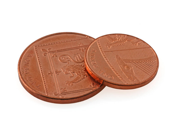 Raha Yhden pennin kolikko, joka lepää kahden pennin kolikolla eristetyllä valkoisella pohjalla
 - Valokuva, kuva