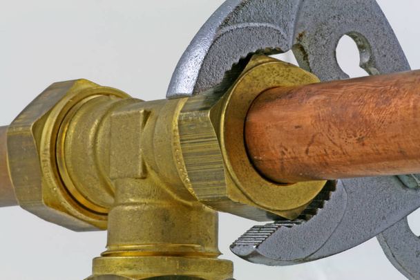 Klempner verstellbarer Schraubenschlüssel zum Anziehen von Kupferrohren ein verstellbarer Schraubenschlüssel zum Anziehen einer Druckverbindung zu 15mm Kupferrohren auf grauem Hintergrund - Foto, Bild
