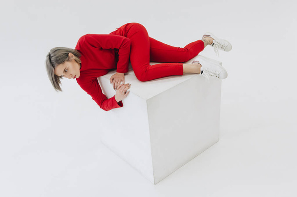 woman in red clothes on white cube - Foto, imagen