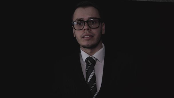 Portrait of a handsome young businessman in glasses, in suit, black background. - Foto, Imagem