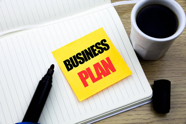 Hand writing text caption inspiration showing Business Plan. Business concept for Mission or Vision written on sticky note paper, Wooden background with space, Coffee and marker - Photo, Image