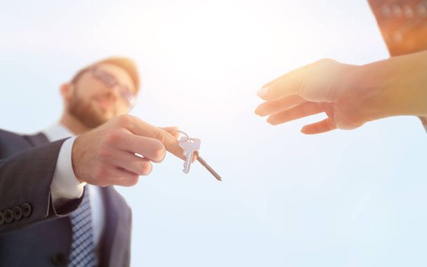 Cropped image of estate agent giving house keys to man in office - Фото, изображение