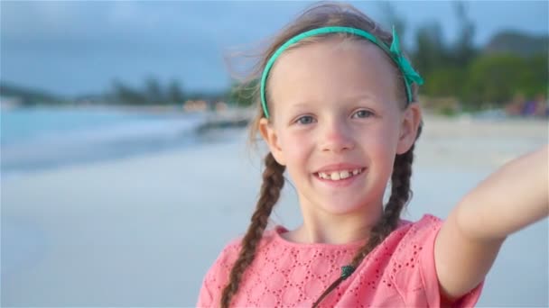 Adorable petite fille prenant selfie à la plage de sable blanc tropical. MOTION DE LENT
 - Séquence, vidéo