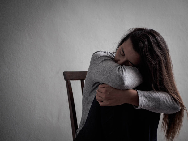 Депрессивная женщина с разбитым сердцем сидит одна в темной комнате дома
 - Фото, изображение